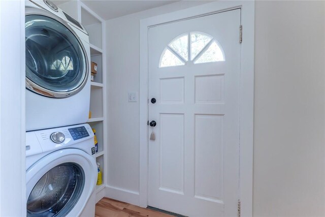 laundry area featuring stacked washing maching and dryer and light hardwood / wood-style floors