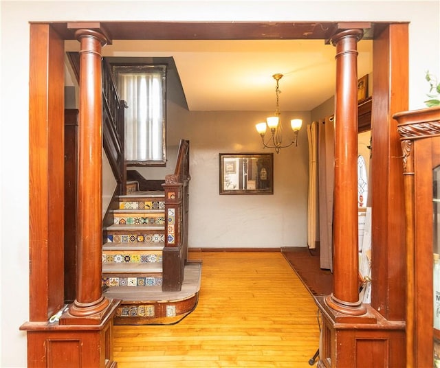 staircase with hardwood / wood-style floors and an inviting chandelier