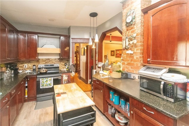 kitchen with pendant lighting, light hardwood / wood-style flooring, decorative backsplash, custom range hood, and stainless steel appliances