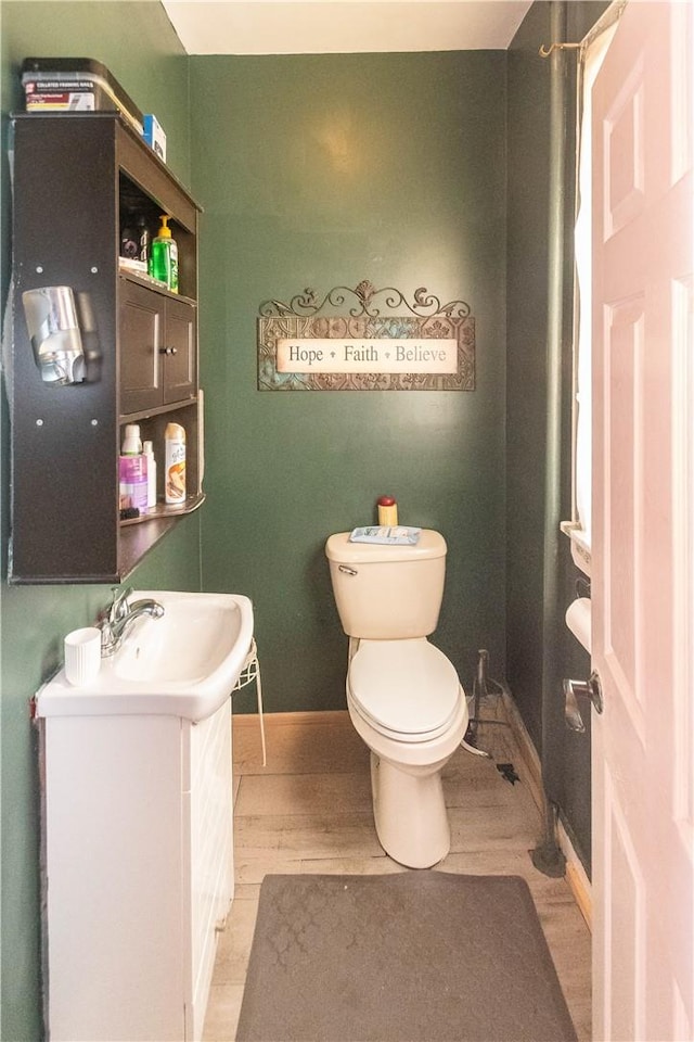 bathroom featuring vanity, hardwood / wood-style flooring, and toilet