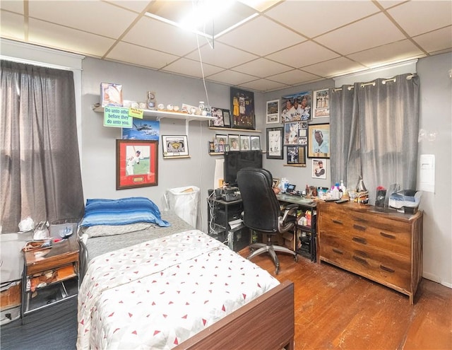 bedroom featuring hardwood / wood-style floors and a drop ceiling