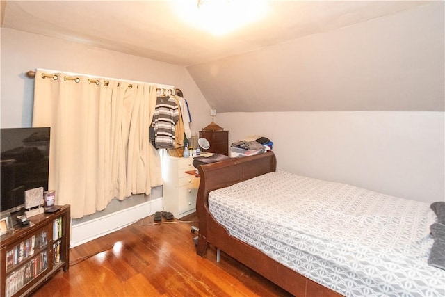 bedroom with lofted ceiling and wood-type flooring