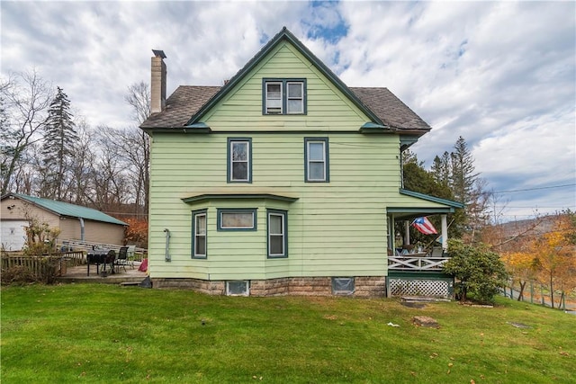 rear view of property featuring a lawn