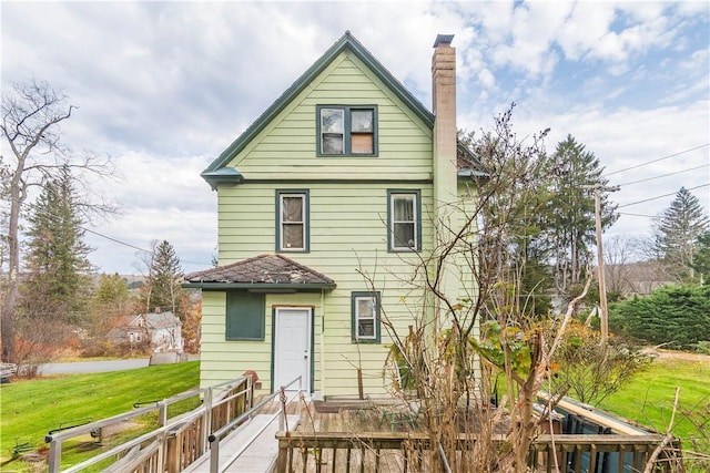 rear view of house with a yard and a wooden deck