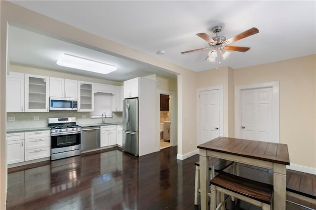 kitchen with white cabinetry, sink, dark wood-type flooring, backsplash, and appliances with stainless steel finishes