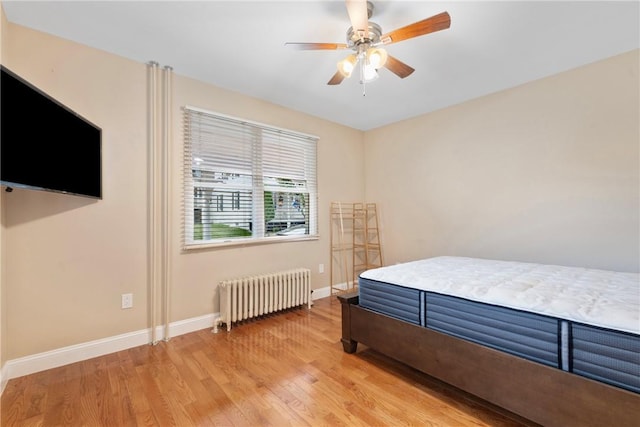 bedroom with radiator, ceiling fan, and wood-type flooring