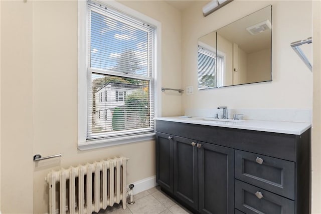 bathroom featuring vanity, tile patterned floors, radiator, and a healthy amount of sunlight