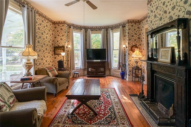 living room featuring ceiling fan, hardwood / wood-style floors, and plenty of natural light