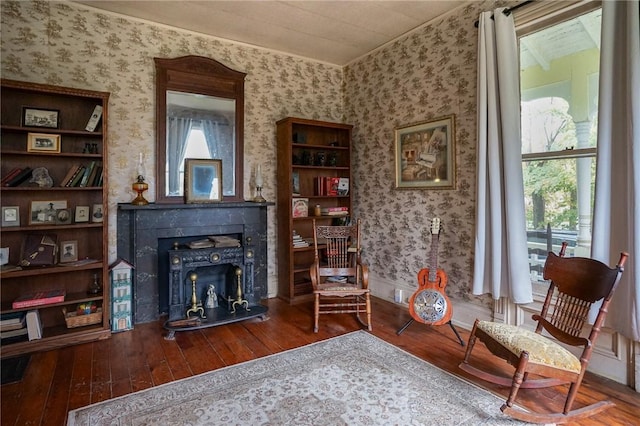 sitting room featuring hardwood / wood-style floors and a wood stove