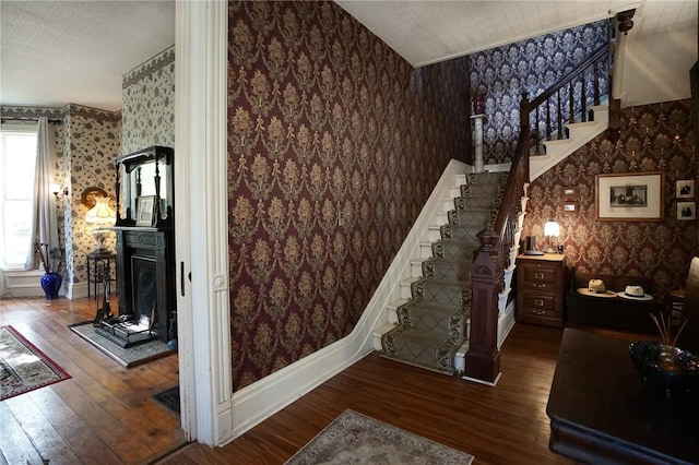 stairs with a textured ceiling and hardwood / wood-style flooring