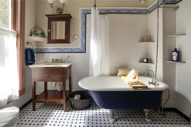 bathroom featuring a tub to relax in, tile walls, and sink