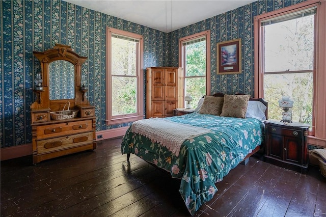 bedroom featuring dark hardwood / wood-style flooring and multiple windows