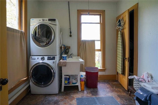 clothes washing area featuring stacked washer and dryer