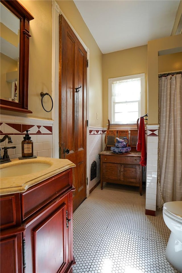 bathroom featuring vanity, toilet, and tasteful backsplash