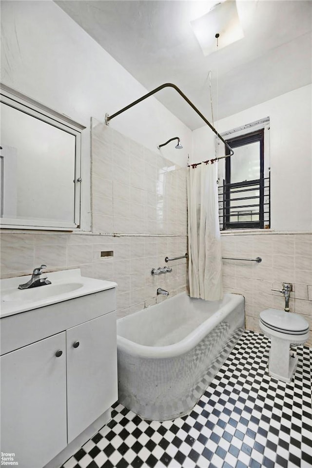 full bathroom with shower / bath combination with curtain, toilet, tile walls, and vanity