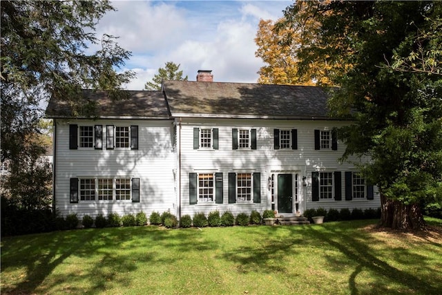 colonial inspired home with a front lawn