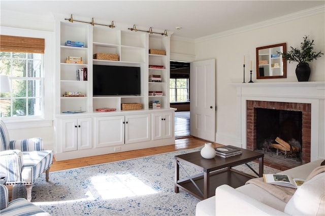 living room featuring hardwood / wood-style floors, ornamental molding, and a brick fireplace