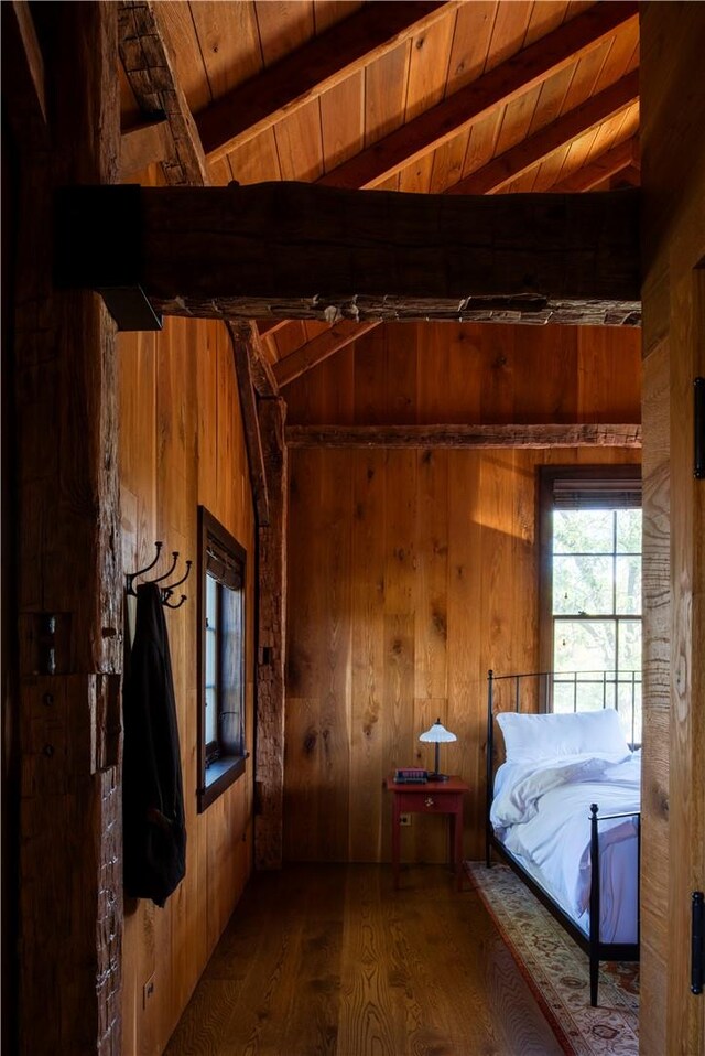 unfurnished bedroom with vaulted ceiling with beams, wood walls, hardwood / wood-style floors, and wooden ceiling