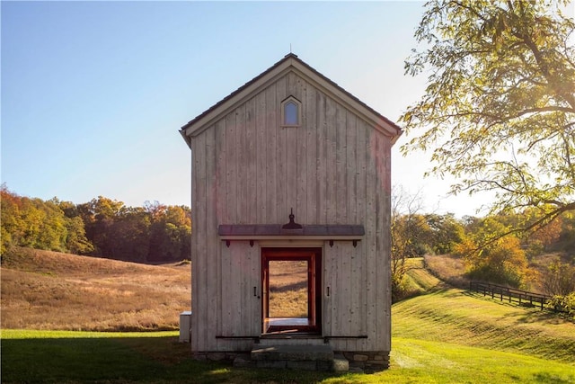 view of outbuilding featuring a yard and a rural view