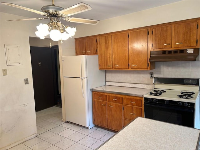 kitchen featuring decorative backsplash, light tile patterned floors, white appliances, and ceiling fan