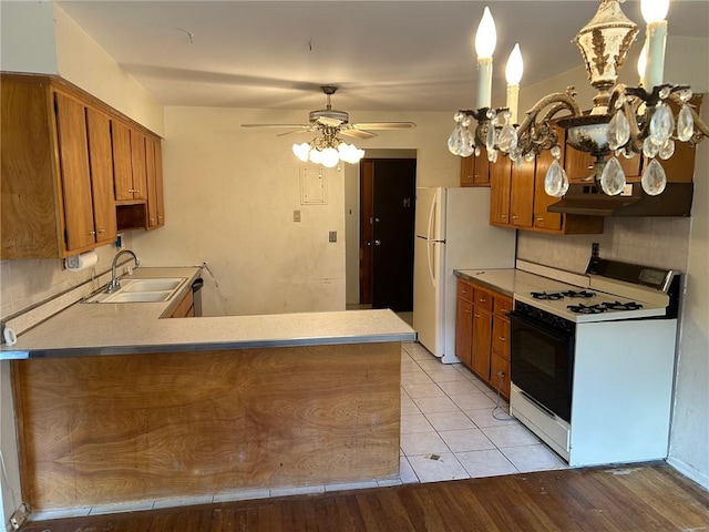 kitchen featuring kitchen peninsula, white appliances, sink, and light hardwood / wood-style flooring