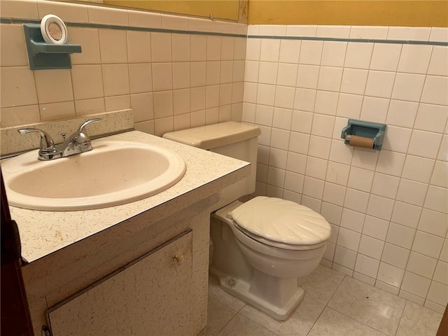 bathroom featuring tile patterned flooring, vanity, tile walls, and toilet