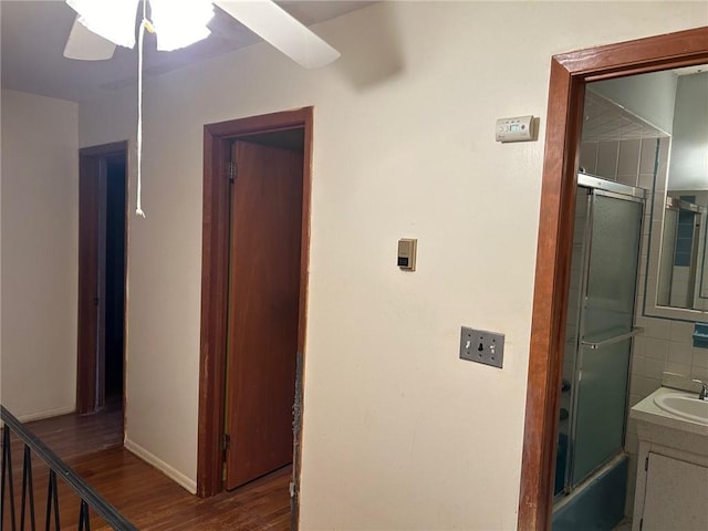 hallway with dark hardwood / wood-style flooring and sink