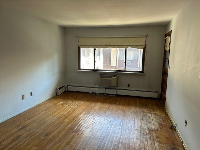 empty room featuring hardwood / wood-style floors, a wall mounted air conditioner, and a baseboard radiator