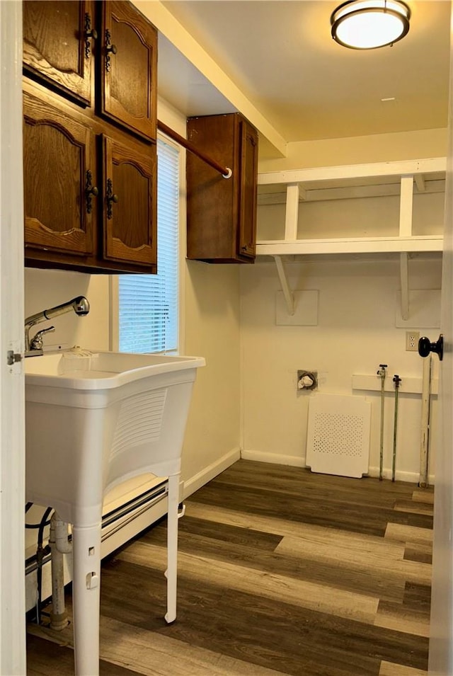 clothes washing area with dark hardwood / wood-style flooring and cabinets