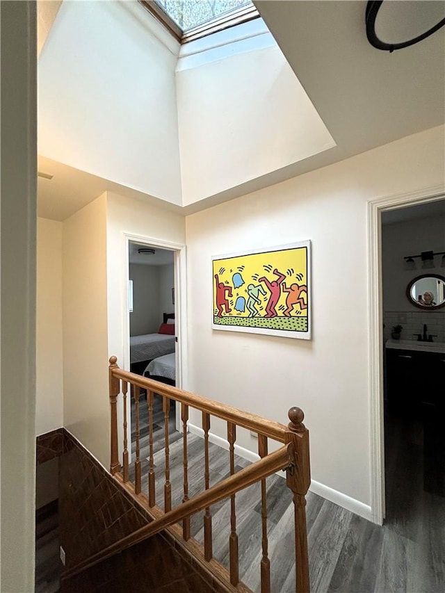 stairs with a skylight and hardwood / wood-style floors