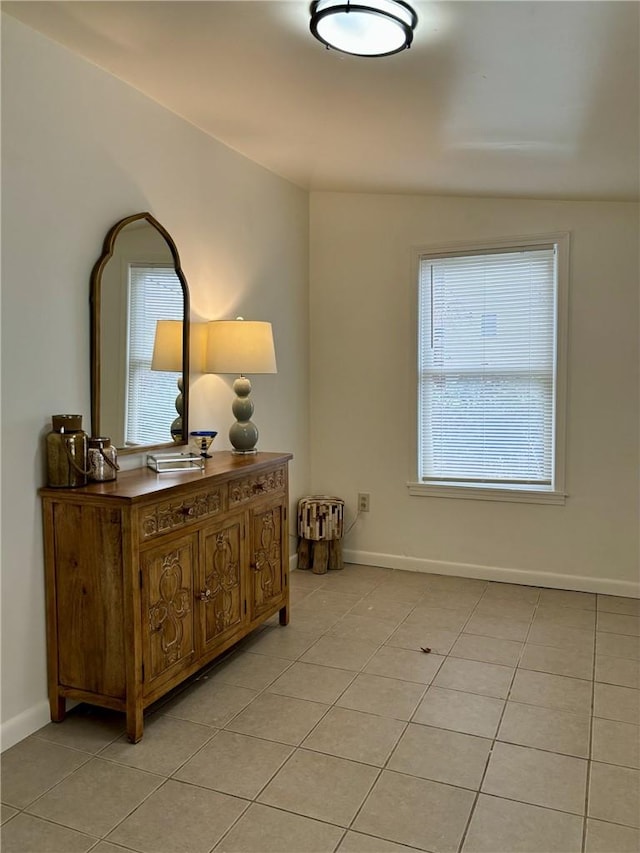 interior space with lofted ceiling and light tile patterned floors