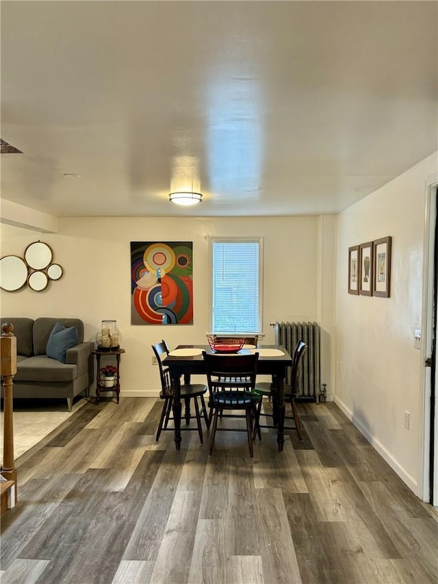 dining space with radiator and dark hardwood / wood-style floors