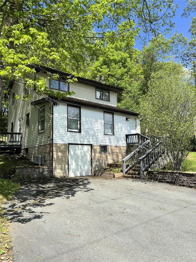 4 Worden Ln, White Sulphur Spring, NY 12787 - view of front of property featuring driveway, a garage, stairway, and central AC unit