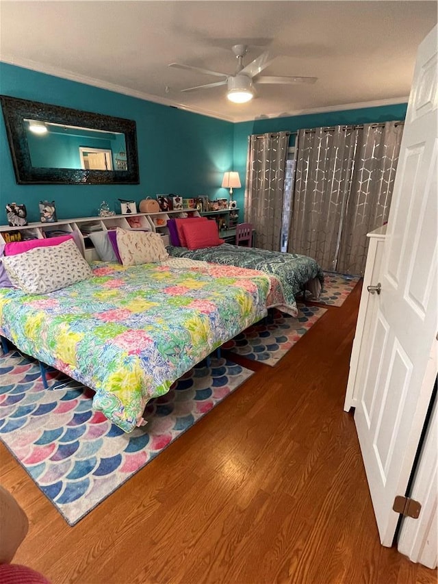 bedroom featuring wood-type flooring, ornamental molding, and ceiling fan