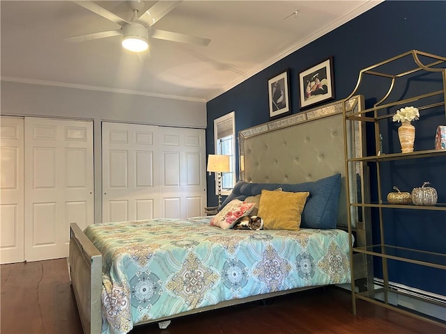 bedroom with multiple closets, crown molding, dark hardwood / wood-style floors, and ceiling fan