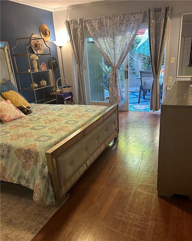 bedroom with dark wood-type flooring, ornamental molding, and access to outside