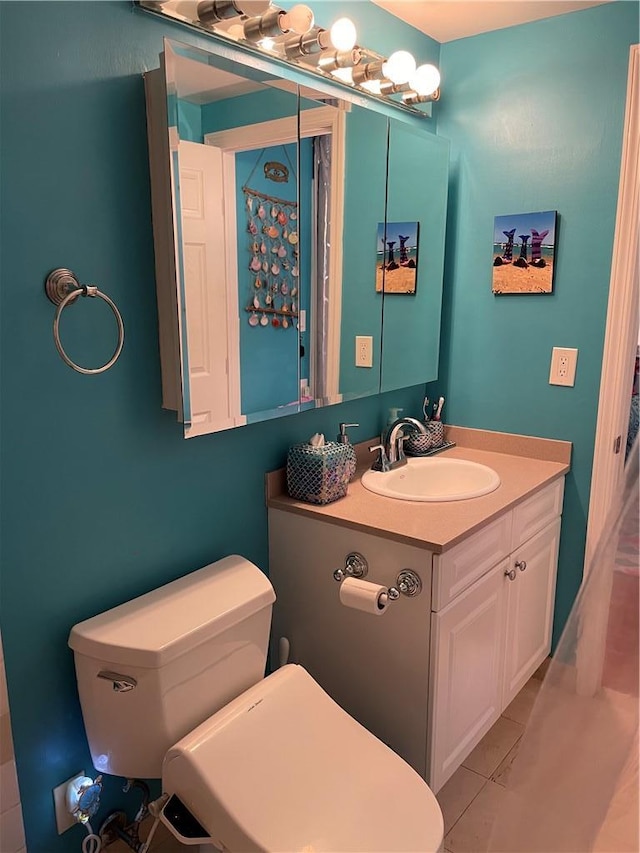 bathroom featuring vanity, toilet, and tile patterned flooring