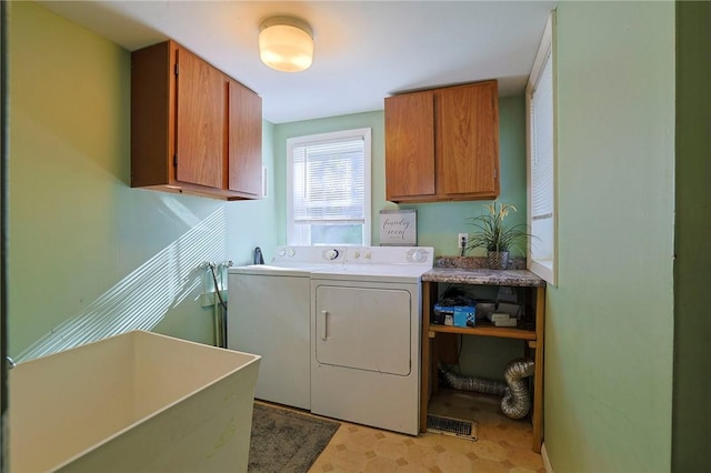 washroom featuring cabinets, washing machine and dryer, and sink