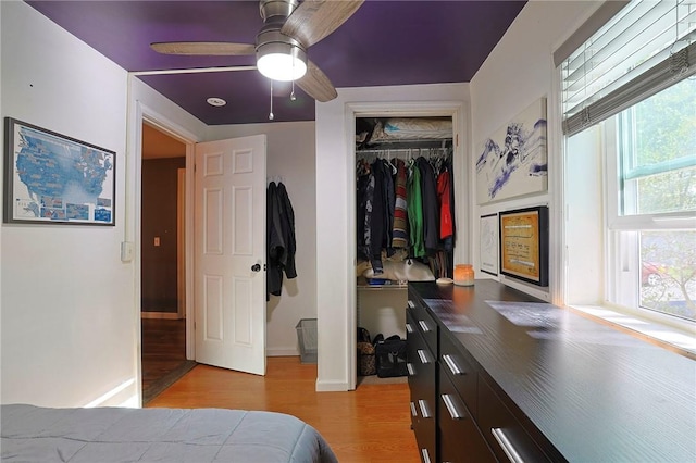 bedroom with light wood-type flooring, a closet, and ceiling fan