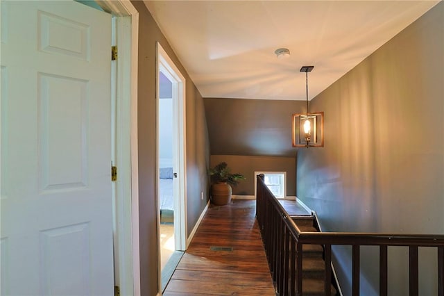 corridor featuring dark hardwood / wood-style flooring and vaulted ceiling