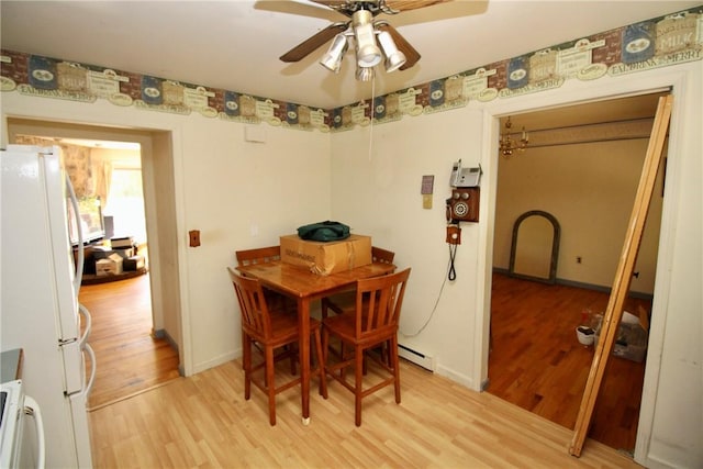 dining room with a baseboard radiator, light hardwood / wood-style flooring, and ceiling fan