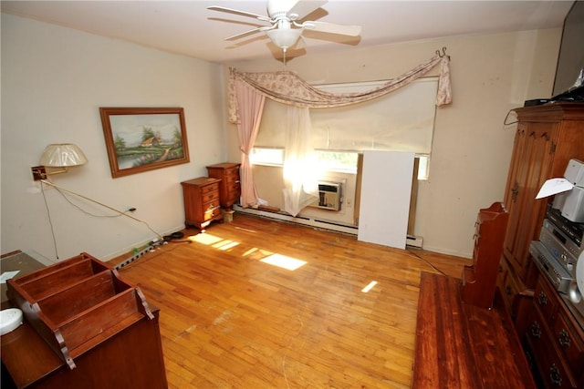 living room featuring baseboard heating, a wall mounted AC, ceiling fan, and hardwood / wood-style flooring