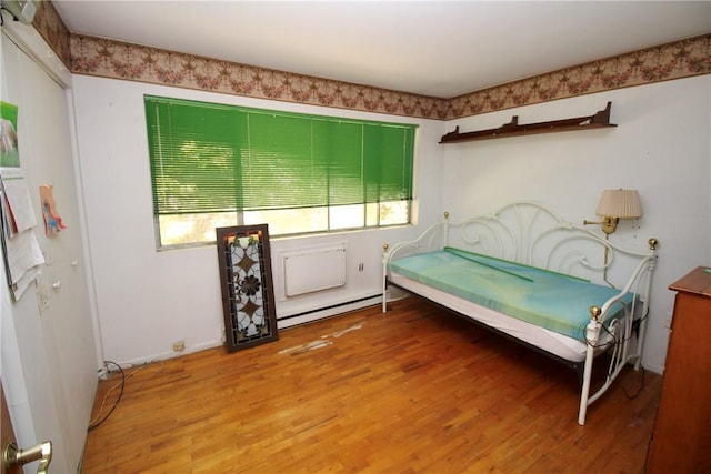 bedroom with hardwood / wood-style flooring and a baseboard radiator