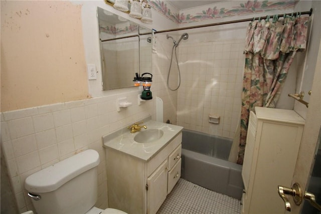 full bathroom featuring tile patterned floors, tile walls, toilet, vanity, and shower / tub combo