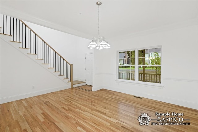 unfurnished dining area featuring wood-type flooring and a notable chandelier