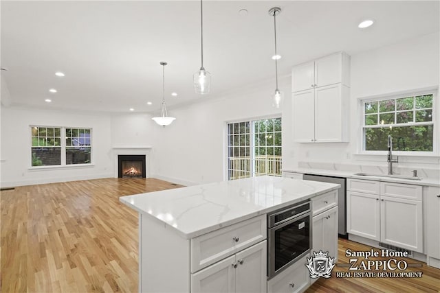 kitchen with white cabinetry, sink, and a healthy amount of sunlight