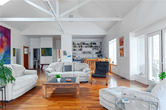 living room with beamed ceiling, high vaulted ceiling, and light hardwood / wood-style flooring