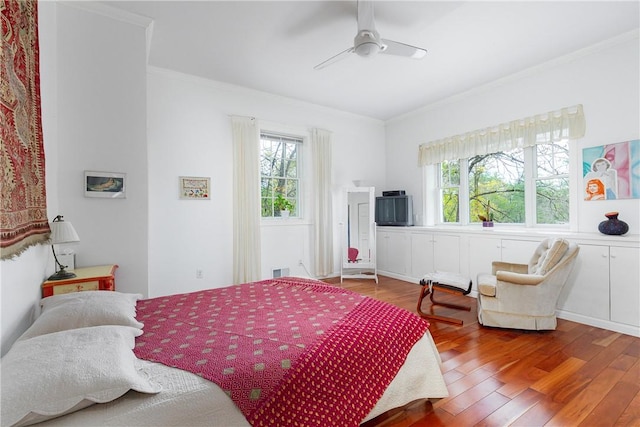 bedroom with hardwood / wood-style flooring, ceiling fan, and crown molding