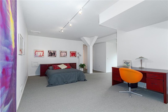 carpeted bedroom featuring track lighting