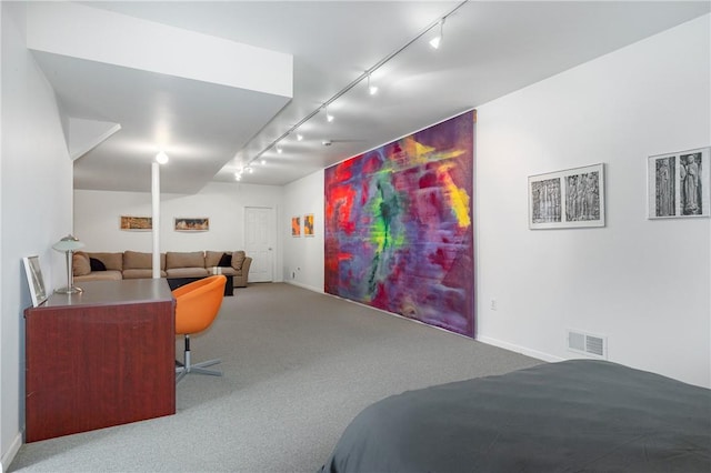 carpeted bedroom featuring rail lighting